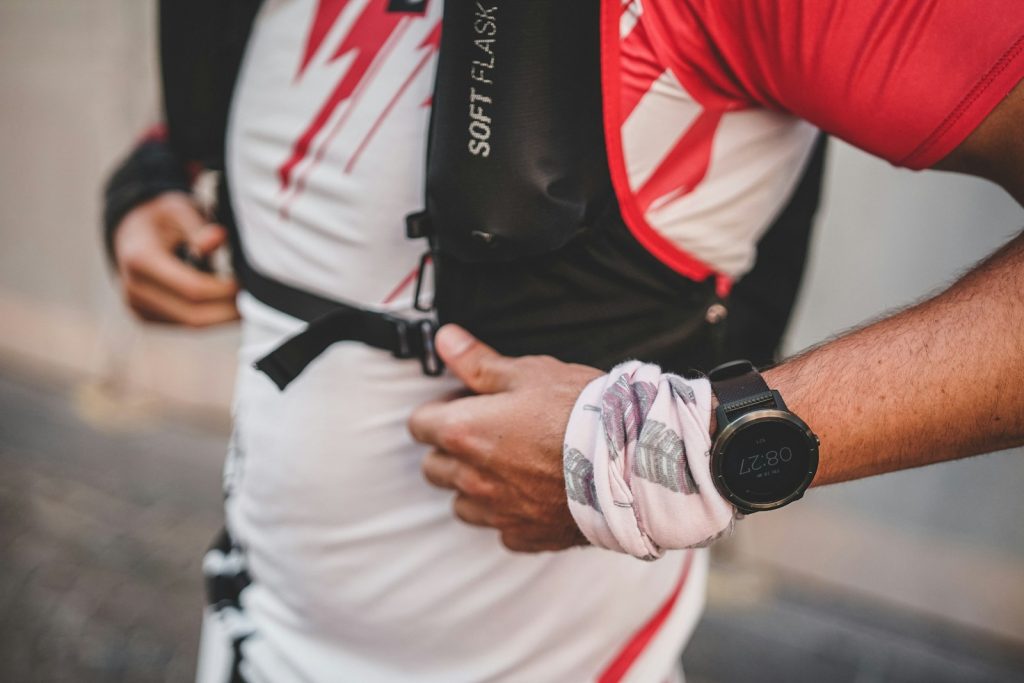 man running wearing backpack and garmin